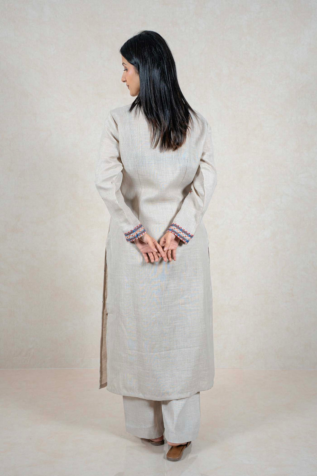 Raysham Fashion beige linen kurta set with embroidered cuffs on a woman seen from the back