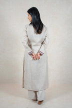 Raysham Fashion beige linen kurta set with embroidered cuffs on a woman seen from the back