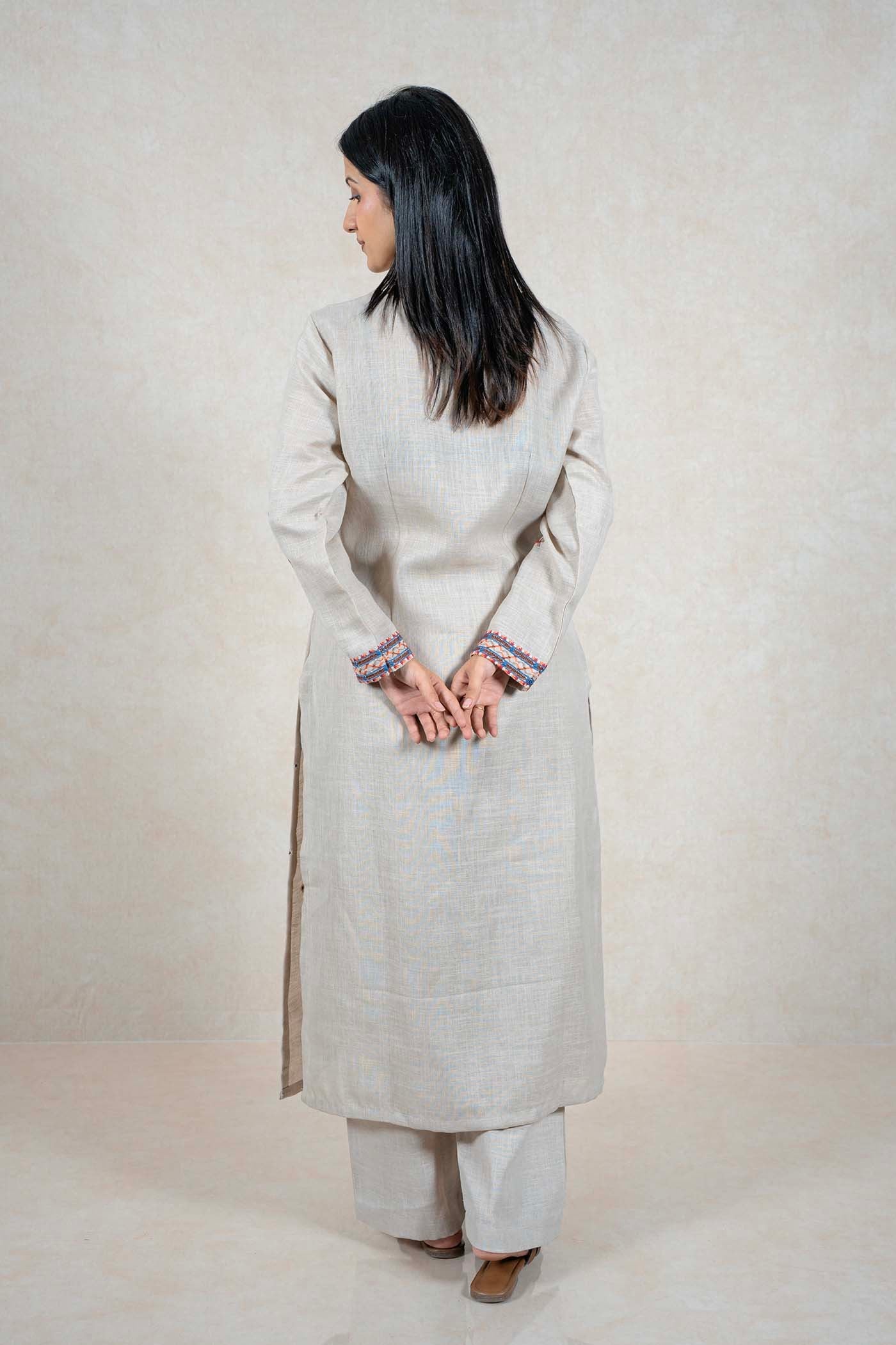 Raysham Fashion beige linen kurta set with embroidered cuffs on a woman seen from the back