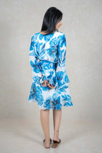Raysham Fashion blue and white floral print long sleeve wrap dress with a tie waist and tiered skirt, back view.