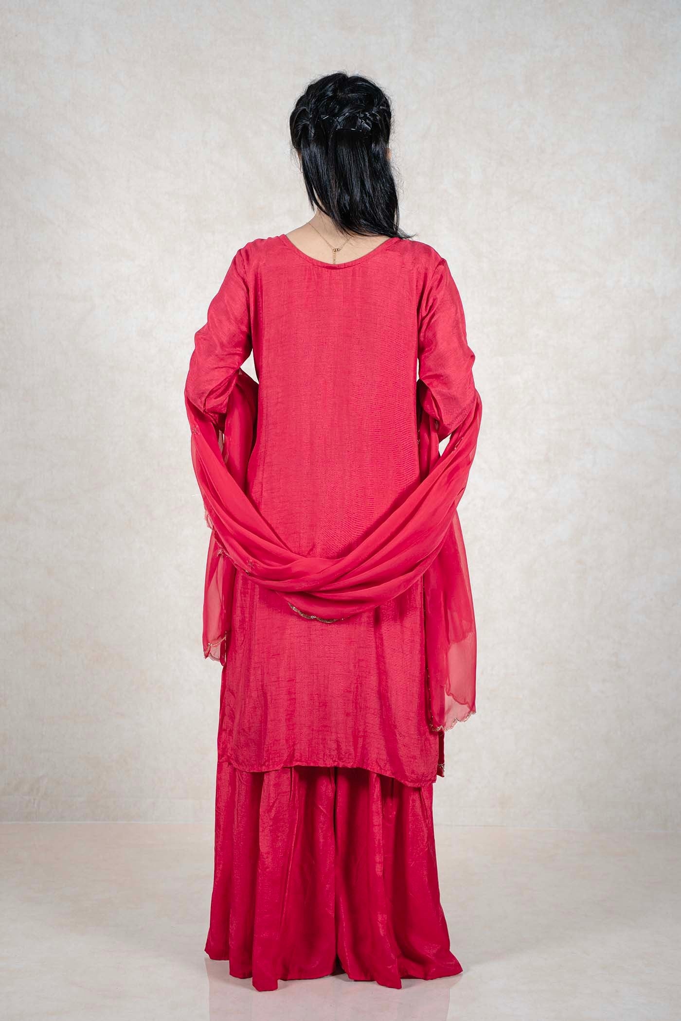 Back view of a woman wearing a crimson red Raysham Fashion silk-blend kurta set with a matching sheer dupatta.