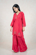 Model wearing a Raysham Fashion crimson red silk-blend kurta set with gold embroidery and matching palazzo pants.