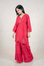 Model wearing a Raysham Fashion crimson red silk-blend kurta set with gold embroidery and matching palazzo pants.
