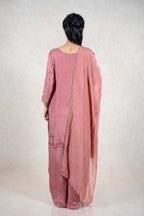 Back view of a woman wearing a dusty rose Raysham Fashion silk-blend kurta set with a sheer embroidered dupatta.