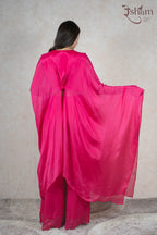Back view of a woman wearing a Raysham Fashion fuchsia pink sheer kaftan cape with matching wide-leg trousers.