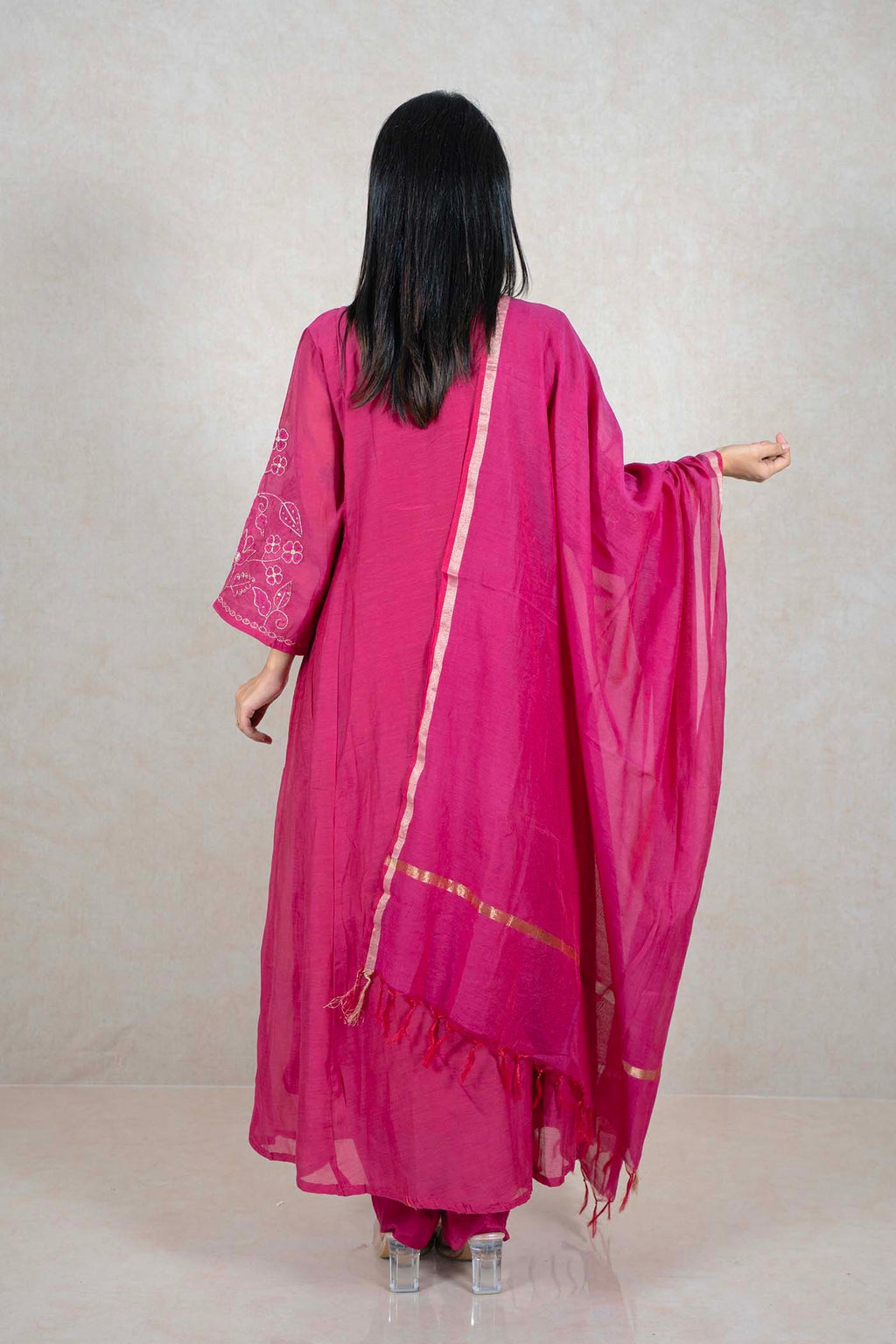 Back view of a woman wearing a fuchsia pink Raysham Fashion silk-blend kurta set with white floral embroidery.