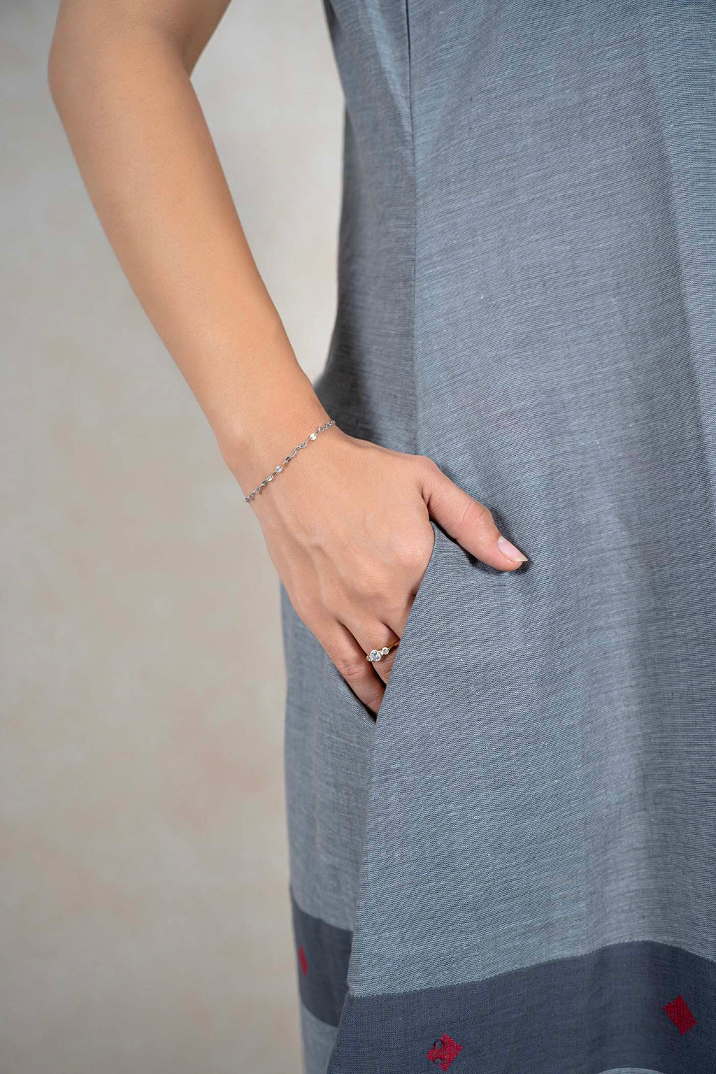 Raysham Fashion grey sleeveless cotton midi dress featuring a side pocket and a contrast hem with red embroidery.