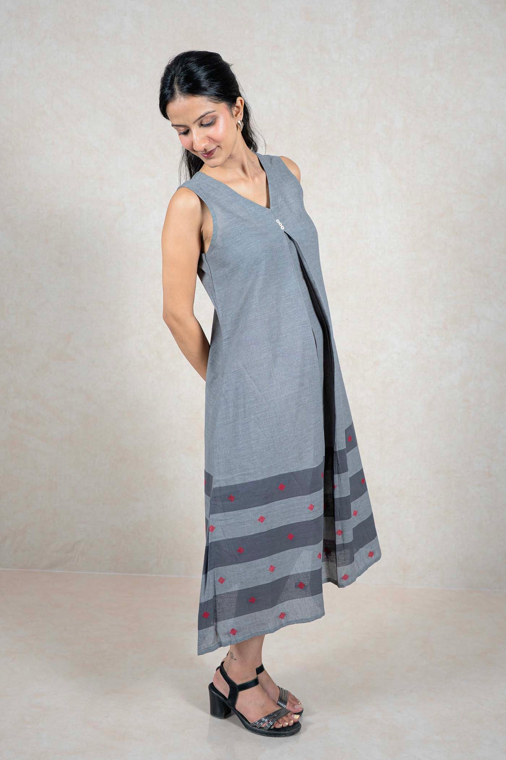 Raysham Fashion sleeveless grey cotton midi dress with V-neck, central pleat, and striped hem with red embroidery.