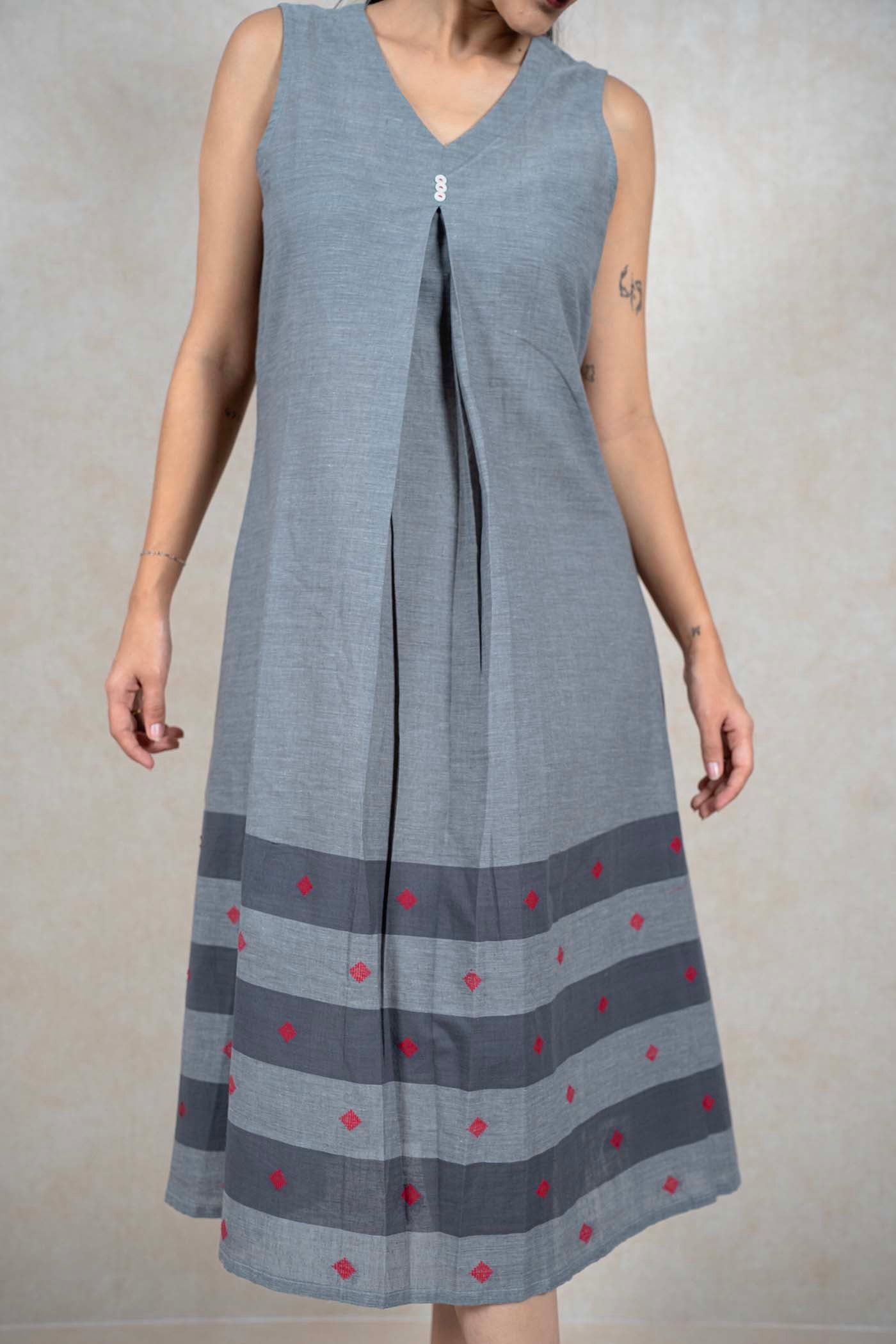 Raysham Fashion grey sleeveless cotton midi dress with V-neck, central pleat, and red diamond embroidery hem detail.