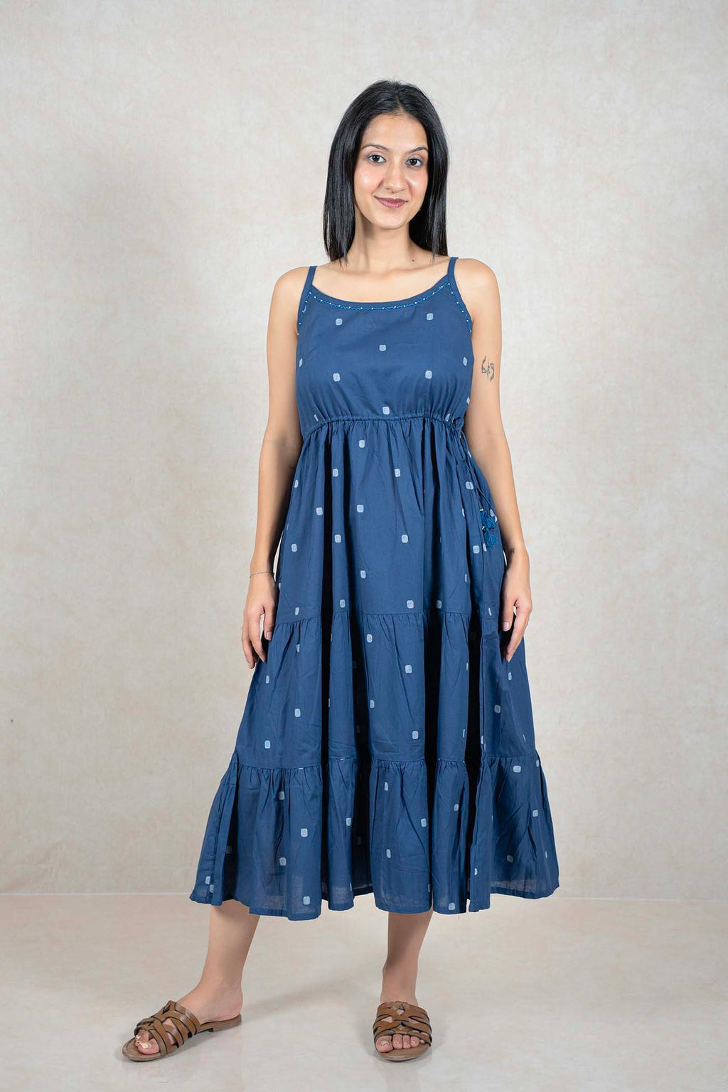 Model wearing a Raysham Fashion indigo blue cotton tiered midi dress with a square print and drawstring waist.