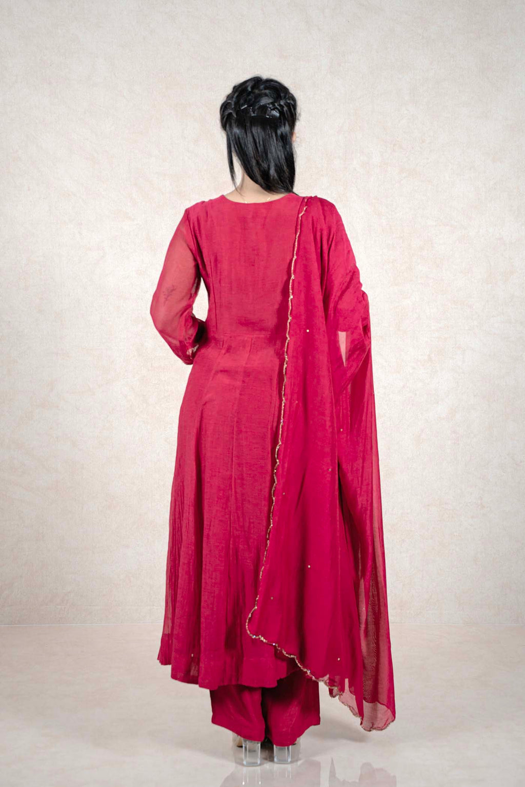 Back view of a woman wearing a Raysham Fashion deep magenta Anarkali suit with a sheer dupatta and gold trim.