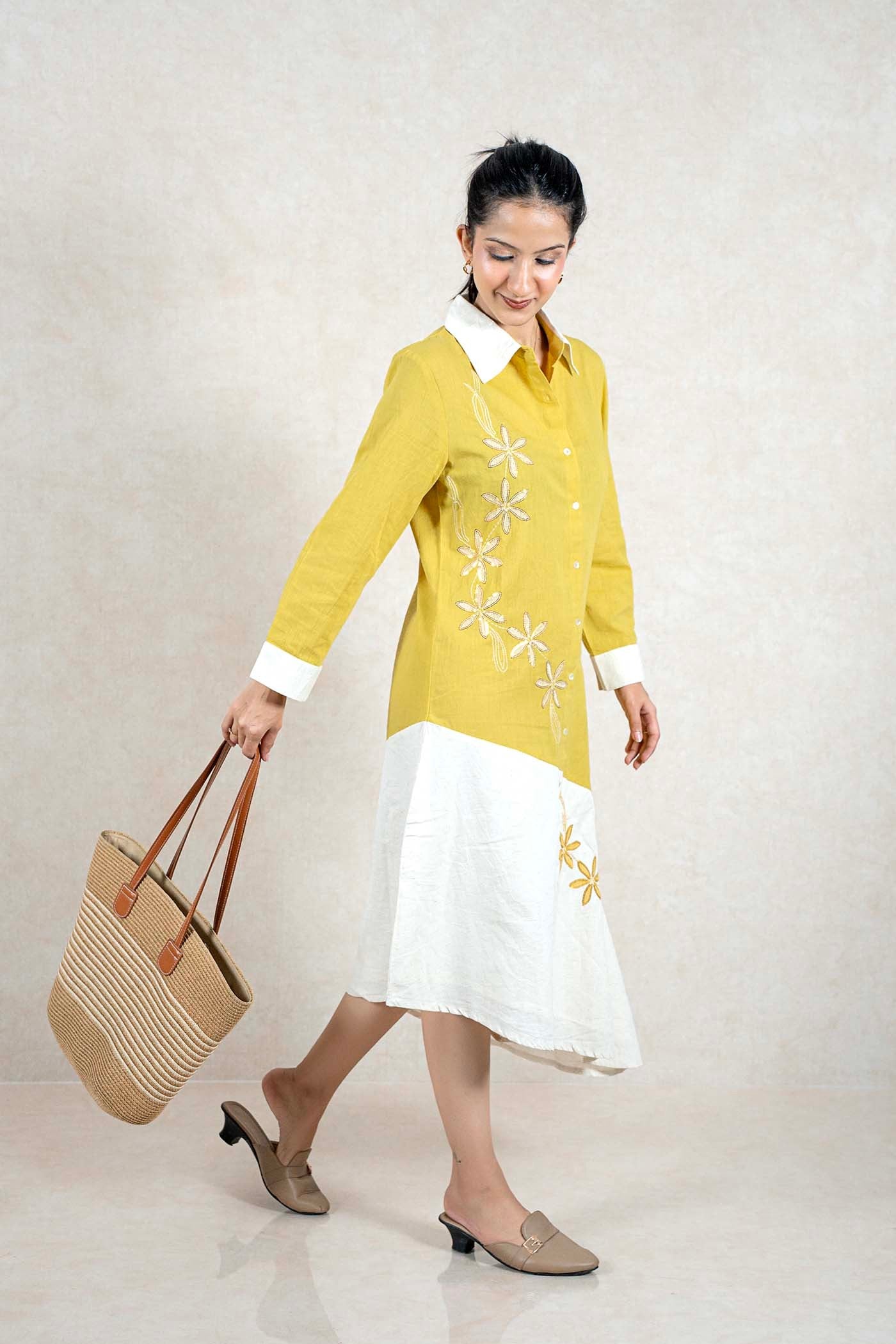 Raysham Fashion mustard and white asymmetric shirt dress with floral embroidery, worn by a model holding a tote bag.