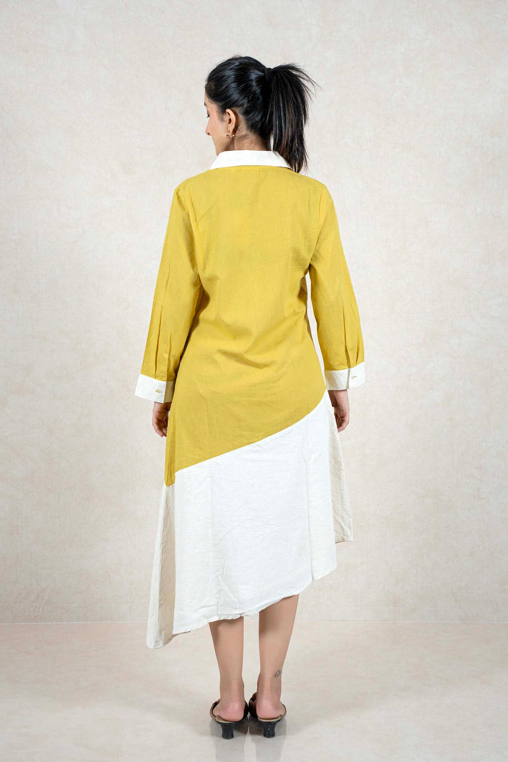 Raysham Fashion mustard and off-white asymmetrical shirt dress with long sleeves and a diagonal hemline, back view.