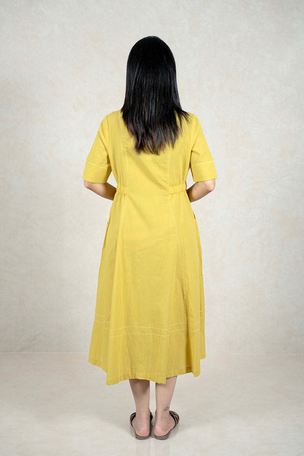 Back view of a Raysham Fashion mustard yellow midi dress with white embroidery details and short sleeves