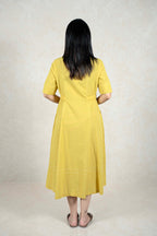 Back view of a Raysham Fashion mustard yellow midi dress with white embroidery details and short sleeves