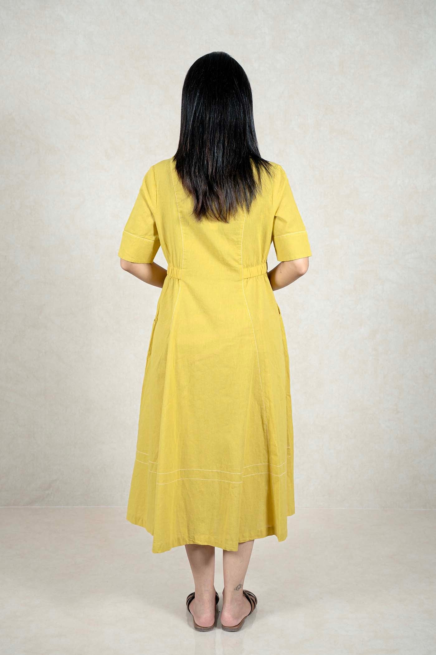 Back view of a Raysham Fashion mustard yellow midi dress with white embroidery details and short sleeves