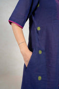 Raysham Fashion navy blue cotton midi dress with lime green polka dots, pink trim, and side pockets on a model