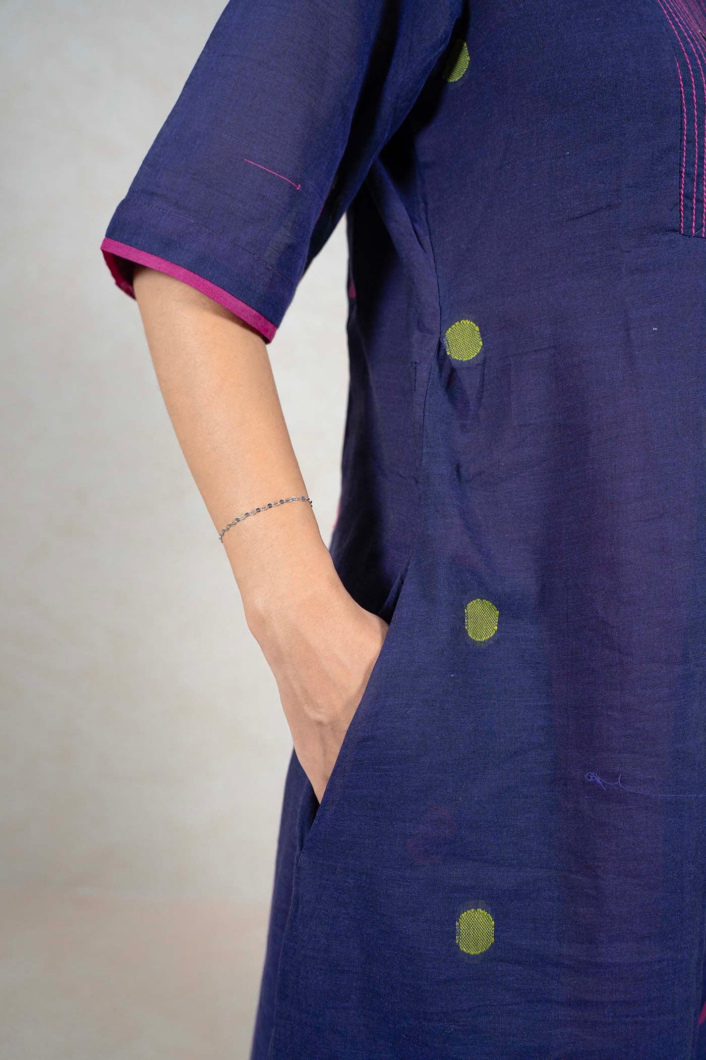 Raysham Fashion navy blue cotton midi dress with lime green polka dots, pink trim, and side pockets on a model