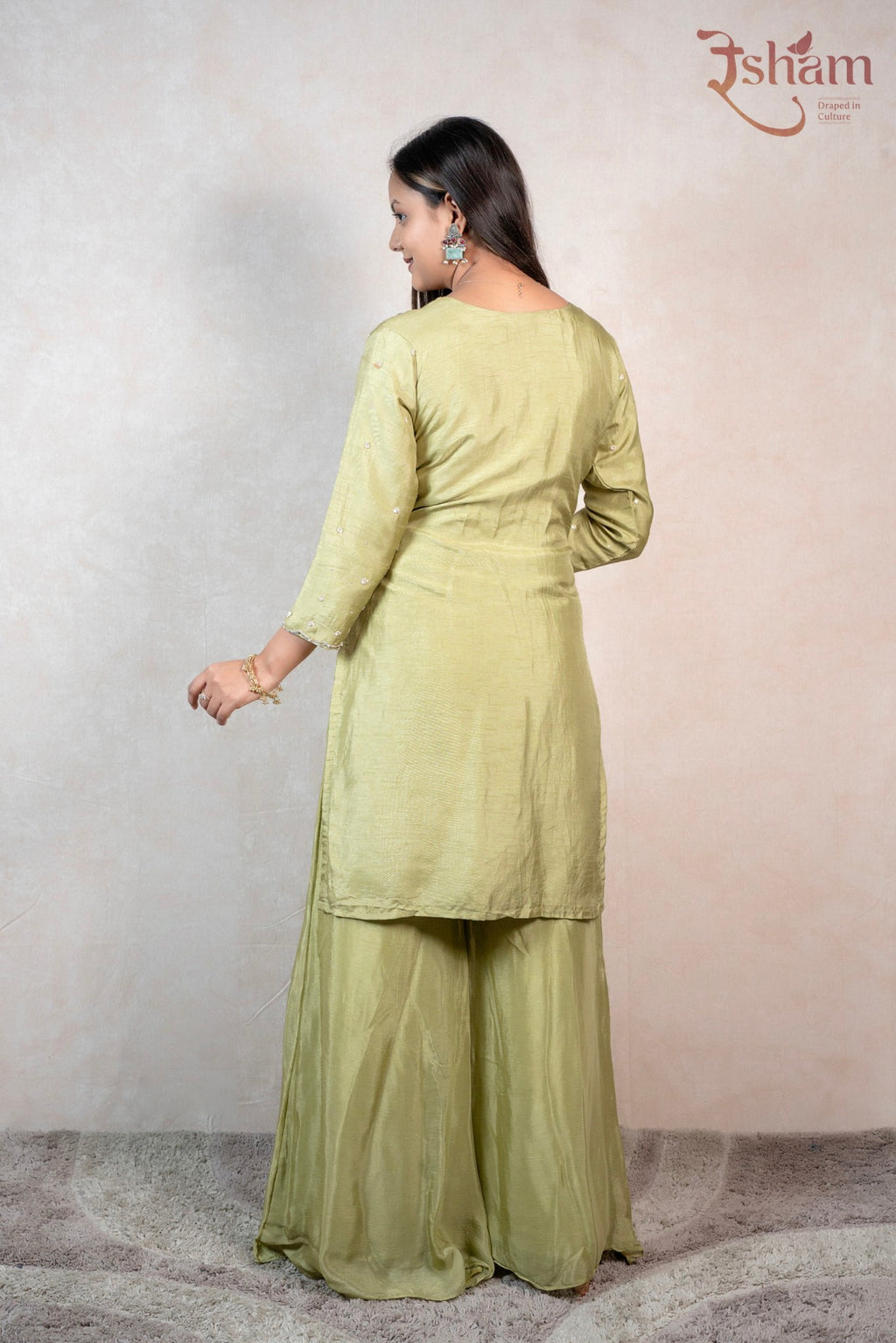 Back view of a woman wearing a Raysham Fashion olive green embroidered kurta and matching flowy sharara set.