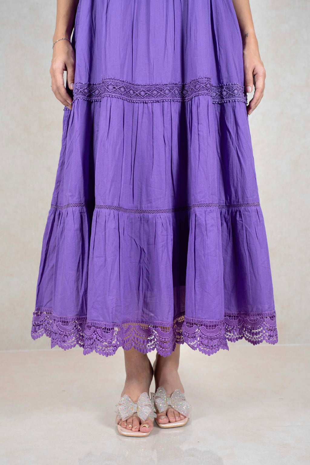 Raysham Fashion purple tiered midi dress with intricate lace trim and side pockets, worn with sparkly bow sandals.