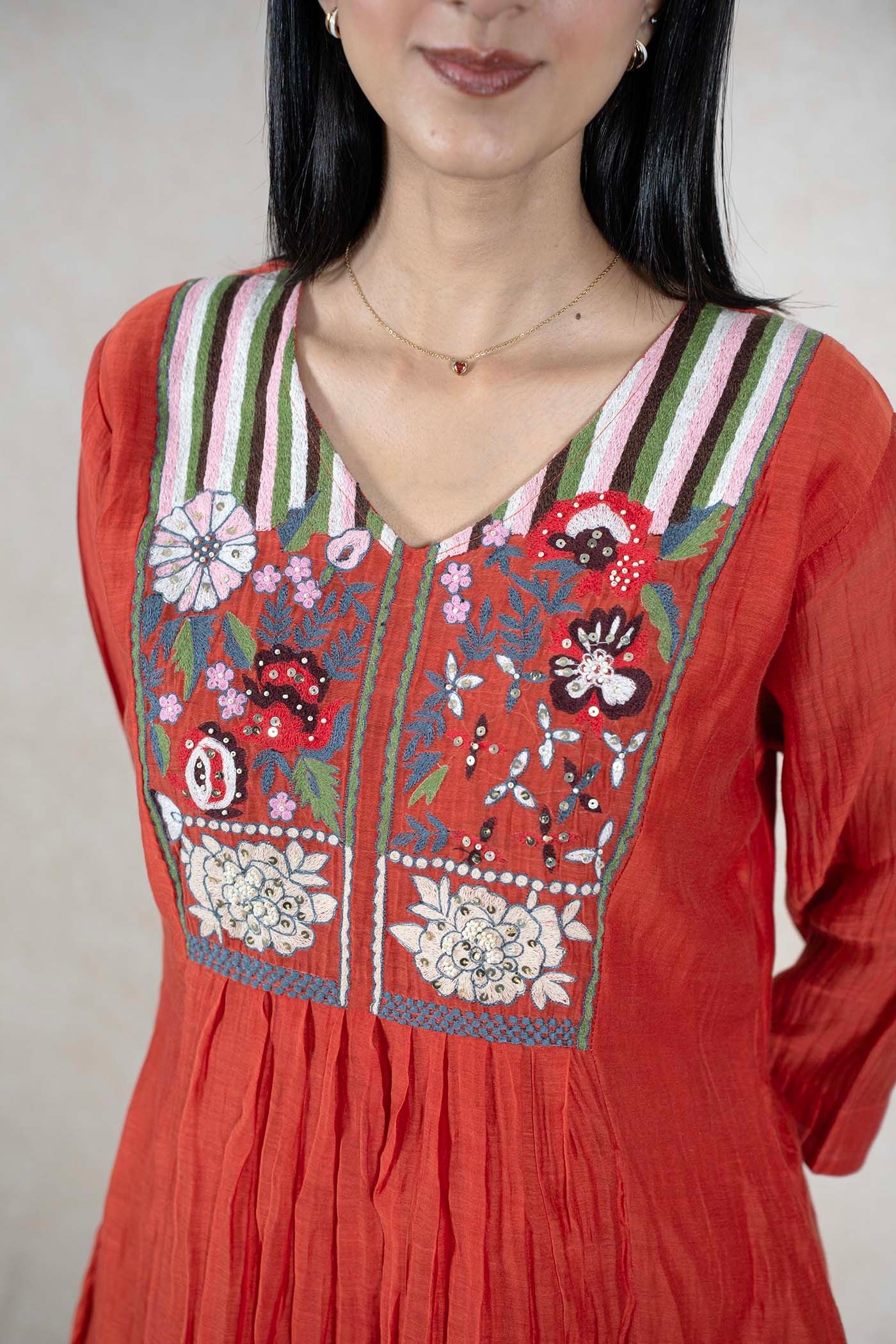 Raysham Fashion rust-orange kurta featuring an embroidered V-neck yoke with floral motifs, sequins, and striped detail.