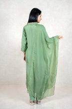 Back view of a woman wearing a sage green Raysham Fashion silk kurta set with embroidered dupatta and trousers.