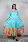 Raysham Fashion turquoise tiered maxi dress with floral print, pink embroidered yoke, and striped cuffs on a model.