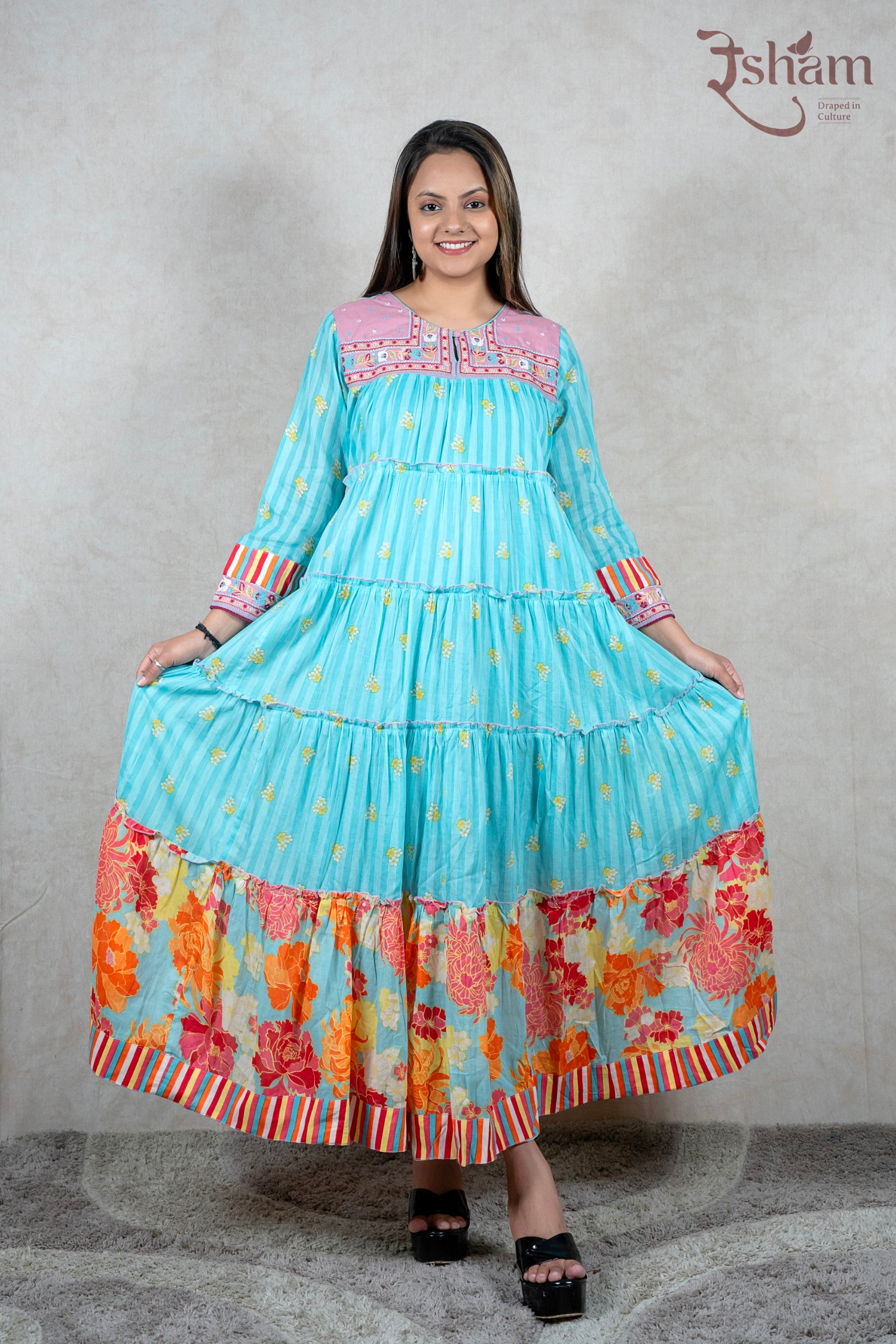 Raysham Fashion turquoise tiered maxi dress with floral print, pink embroidered yoke, and striped cuffs on a model.