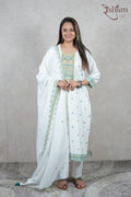 A woman wearing a white Raysham Fashion cotton kurta set with multi-coloured embroidery and a matching dupatta.