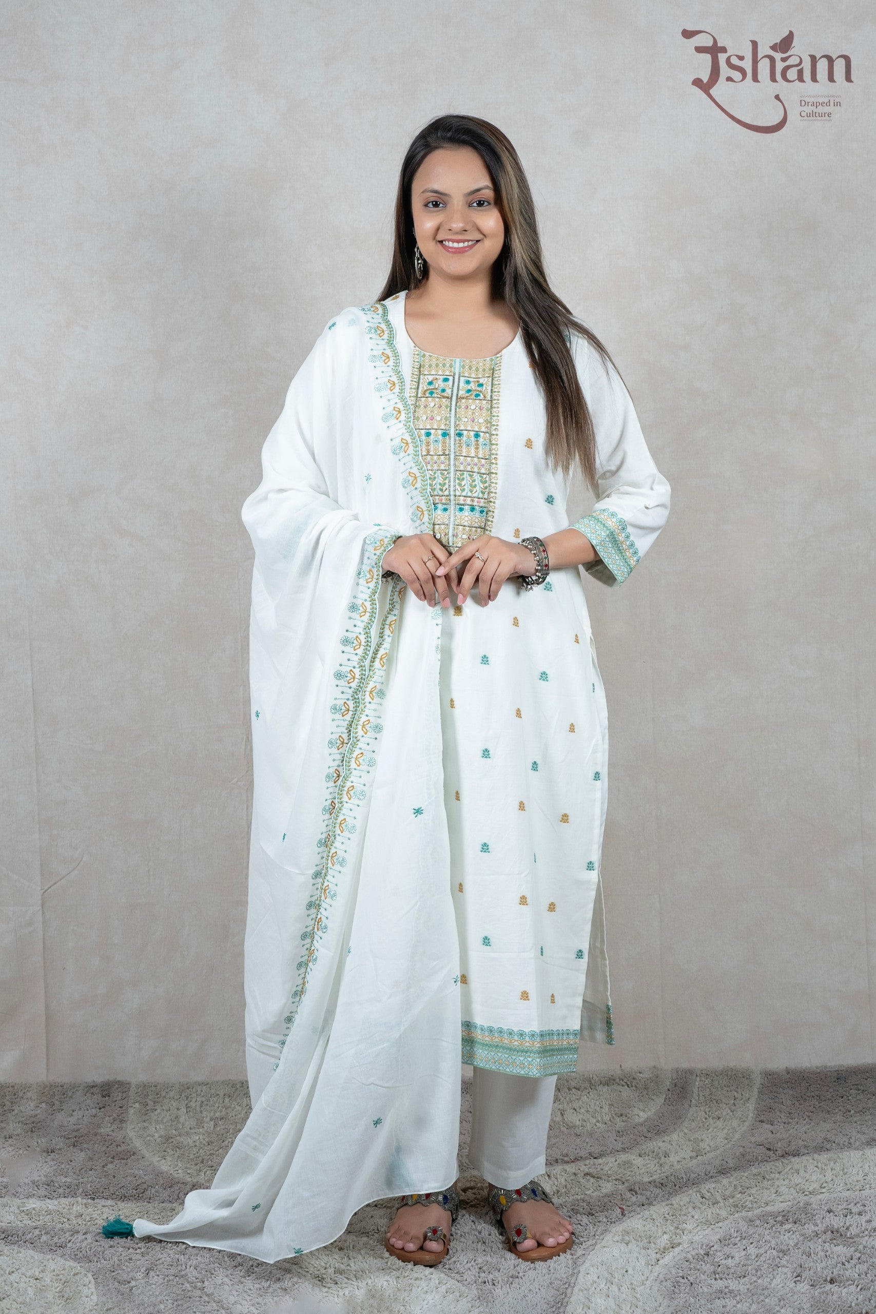 A woman wearing a white Raysham Fashion cotton kurta set with multi-coloured embroidery and a matching dupatta.